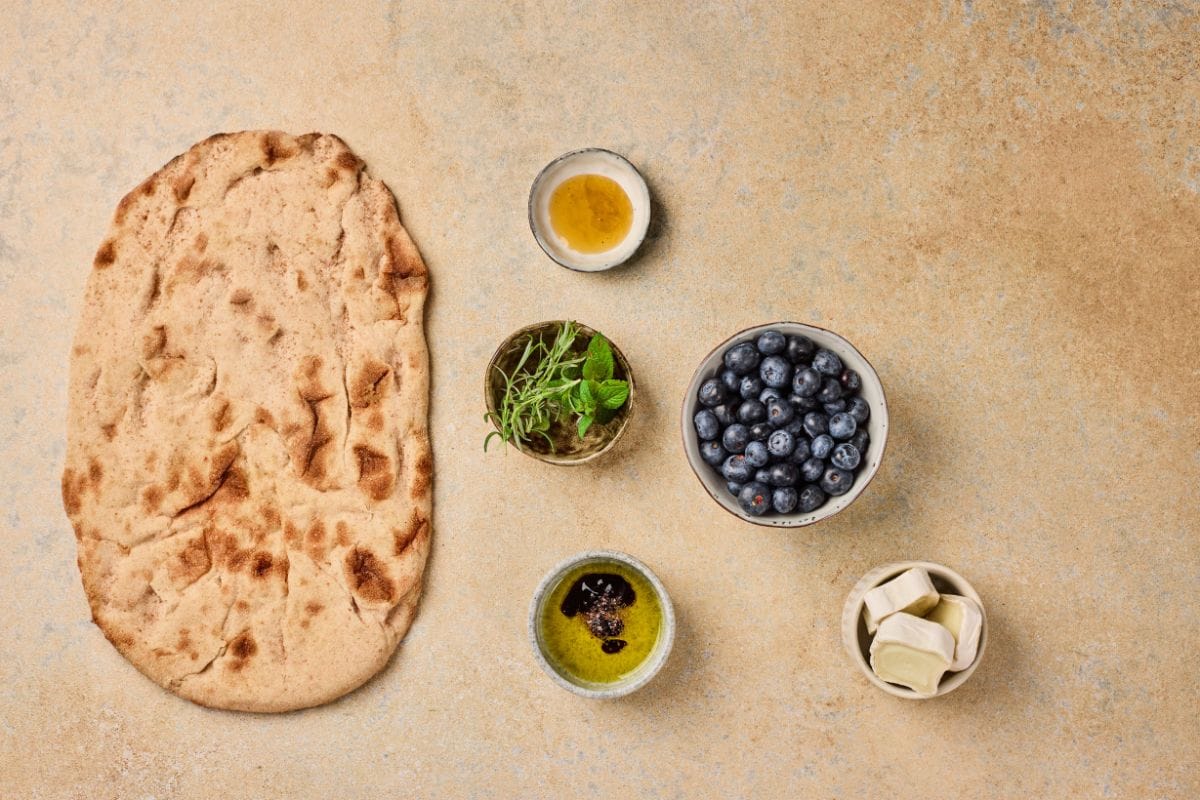 Flatbread with blueberries, herbs, and oils for a healthy snack or meal.