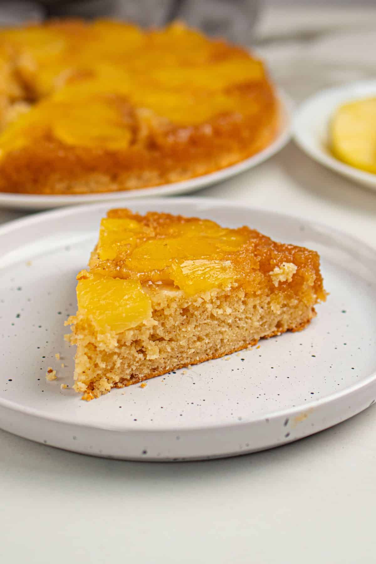 Delicious peach cake with fresh fruit topping on a white plate. Perfect for dessert or afternoon snack.